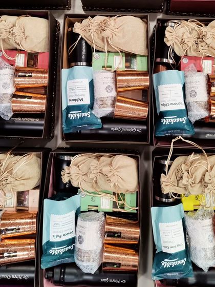 A top-down view of a bulk hamper order ready for dispatch. Each box is consistently packed with items like personalized flasks, copper mugs, and snack pouches, showcasing my ability to handle large-scale corporate gifting with precision.