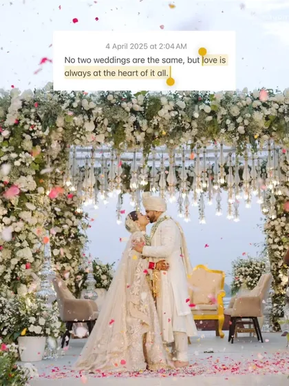 A kiss that seals the promise of a lifetime, captured under a magnificent floral mandap. The shower of petals makes this moment even more magical and memorable.