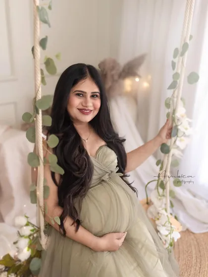 A bright and happy solo portrait on the swing. Her beautiful smile and the soft, rustic styling of the set create a warm and inviting maternity photo.