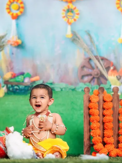 A happy little Krishna celebrates Janmashtami in our colorful and festive studio setup, complete with a pot of butter.