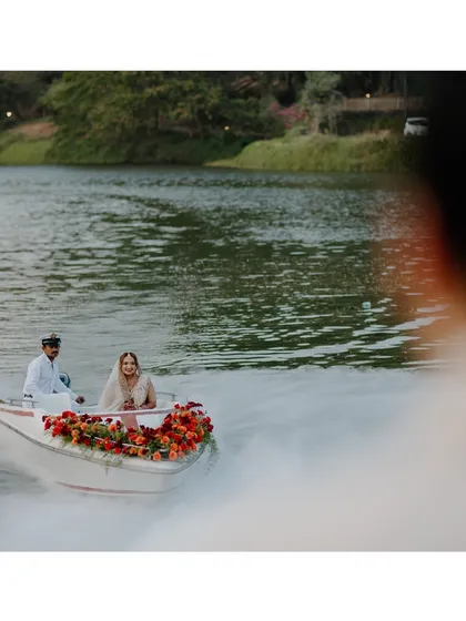 A unique perspective of the couple's boat entry, shot through a gap. This creative framing makes the viewer feel like they are catching a secret, magical glimpse of the moment.