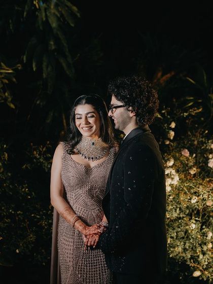 A sweet, candid moment in a beautifully lit garden. The couple's gentle interaction and smiles feel natural and unposed, perfectly capturing their easy chemistry.