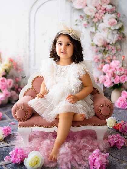 "Two" cute to handle! This little princess is sitting pretty in a pink armchair for her second birthday portraits.