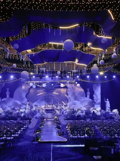 An epic, space-themed reception design. We created a massive custom chandelier and stage setup to look like a celestial scene, transforming a large convention hall into another world.