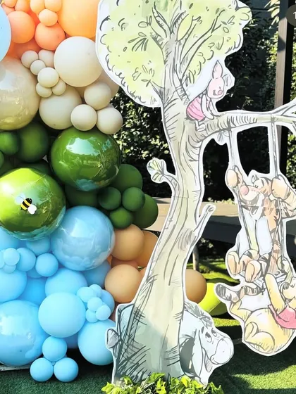 A fun cutout of Pooh, Tigger, and Piglet playing on a tree, adding a dynamic and playful element to the scene.