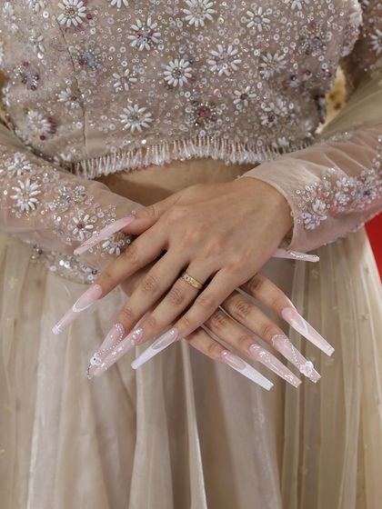 Extremely long, dramatic bridal nails with a milky white base, sugar glitter effect, and delicate stone accents. A true statement set for a bride.