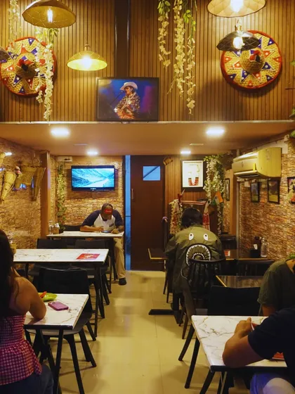 Welcome to our cozy space. We've decorated it with elements from our culture, like the traditional 'Jaapi' on the wall, to make you feel at home while you enjoy your meal.