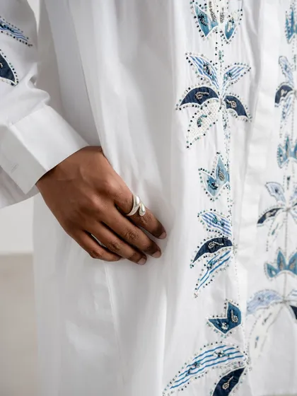 A detail shot focusing on a snake-like ring, worn with an embroidered white shirt. This shows how I integrate accessory styling into a complete fashion look.