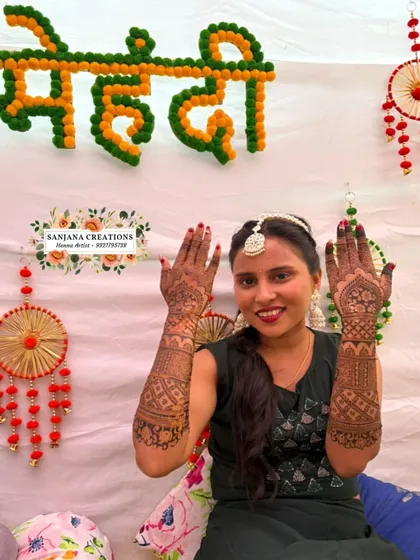 Bride Alisha at her mehndi ceremony, happily showing off her beautiful henna.