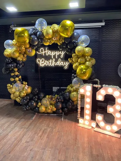 The full view of the 13th birthday setup, showing the large marquee numbers next to the balloon ring.