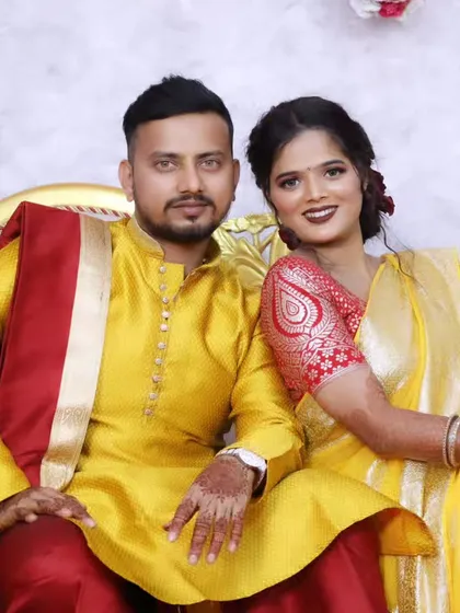 A happy couple portrait, with both bride and groom in coordinated yellow outfits for one of the wedding functions.