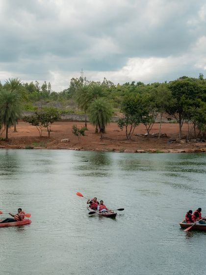 Several groups kayaking and boating on the serene waters of the lake, surrounded by lush greenery.