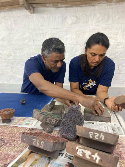 A participant selects from a pile of vintage blocks during a workshop. With over 6000 blocks in our archive, choosing the right design is part of the creative journey.