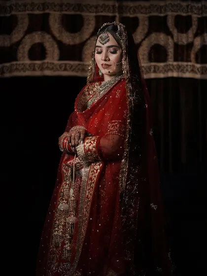 Another stunning professional photograph. The lighting creates a beautiful, moody atmosphere, highlighting the rich details of her outfit and makeup.