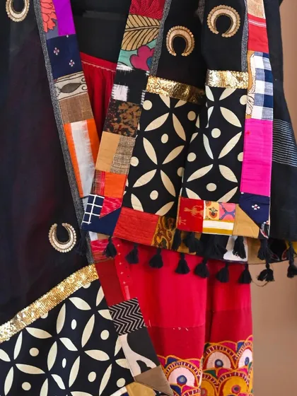 A close-up of the dupatta's corner, revealing the intricate patchwork of fabrics and the shimmering gold Zardozi work that elevates the simple linen.