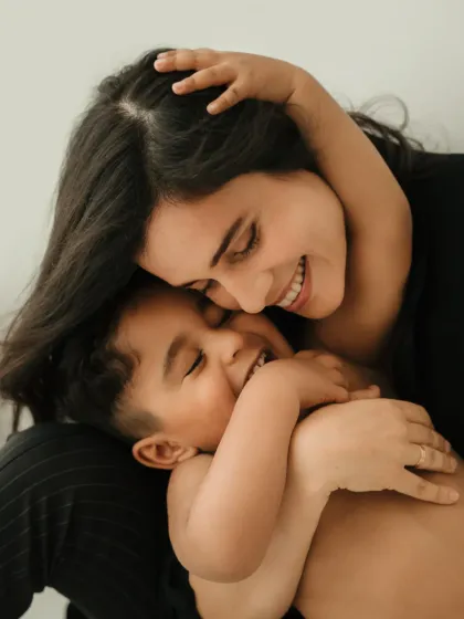 A mother and son share a close, happy hug. This intimate shot perfectly captures the beautiful bond between them.