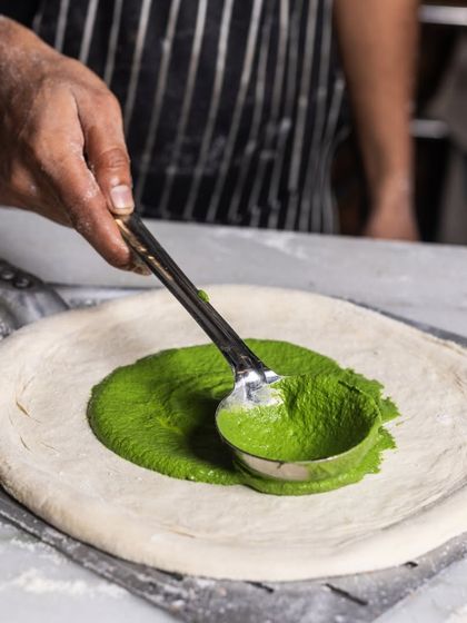 Who said a pizza can only have tomato sauce? Here, I'm spreading a rich spinach and mustard cream for our Mushroom and Burrata pizza.