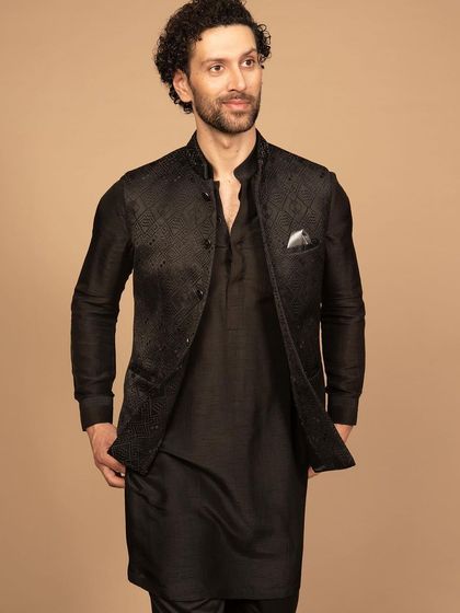The same all-black Nehru jacket and kurta set, showcasing its timeless appeal. The focus is on the silhouette and the rich texture of the fabric, proving that elegance doesn't need to be loud.