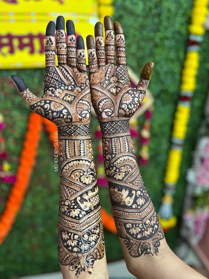 The back of the hands for bride Pooja, featuring a stunning design that uses negative space to create a tree of life effect with birds and florals.