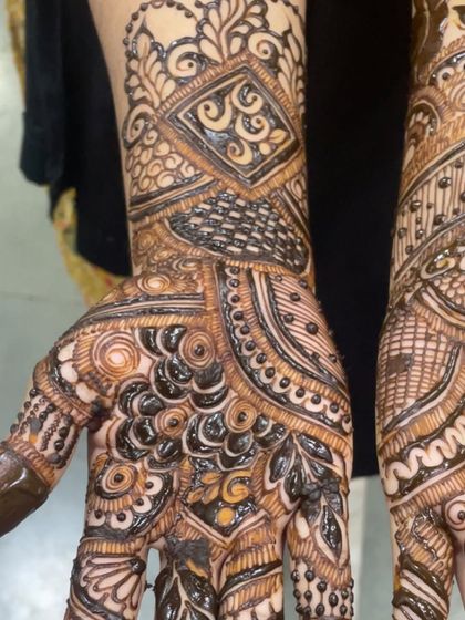 A detailed close up of the wrist and hand portion of a bridal design, highlighting the fine lines and shading work.