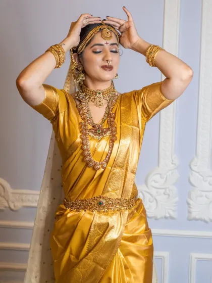 A full view of the bridal attire, showing the perfectly draped saree and the placement of the vaddanam (waist belt). I handle the complete look, including saree draping, to ensure every pleat is perfect.