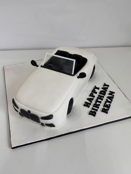 A birthday cake that's ready to roll. This custom cake is sculpted to look like a sleek, white convertible car, making it a stylish and completely edible centerpiece for a car lover's birthday.