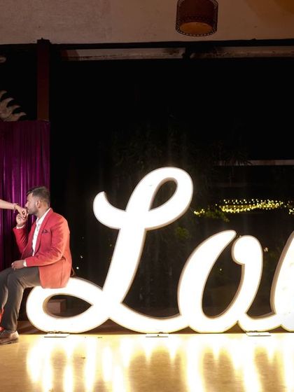 A romantic pose with our large, illuminated 'Love' sign, perfect for a pre-wedding announcement.