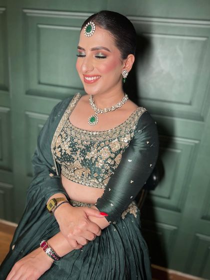A beautiful, happy client. I created this look for a party, featuring a soft green smokey eye to match her lehenga and a sleek, modern bun. Her smile says it all.