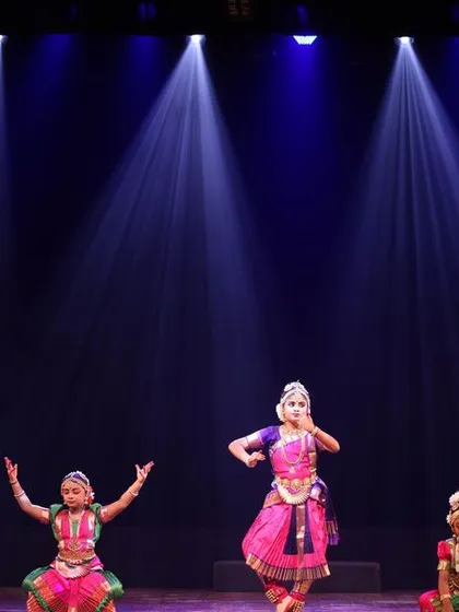 A group of young dancers on stage at the Sadhana festival, with one student taking the lead in the center, showcasing emerging talent.