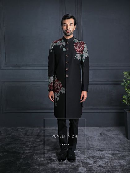 Inspired by the richness of tradition, this black achkan is adorned with vintage rose embroidery. The rich tone of red adds an opulence that reflects luxury at its finest.