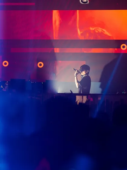 On the mic at a show in Nagpur. The blue and orange lighting creates a dramatic backdrop for an epic night.