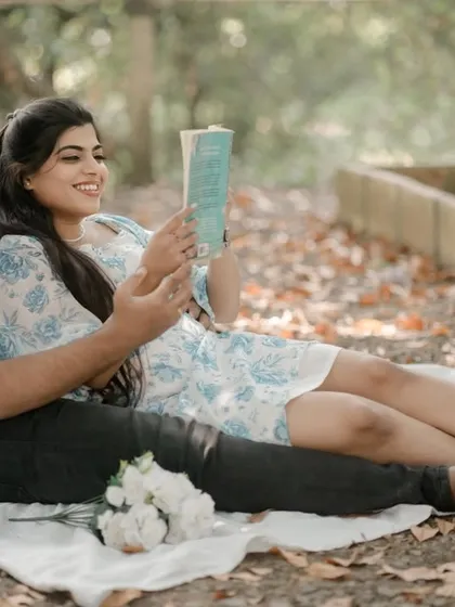 A sweet, cozy moment during a picnic-style shoot. The couple shares a book, creating a relaxed and intimate scene that tells a story about their shared interests.