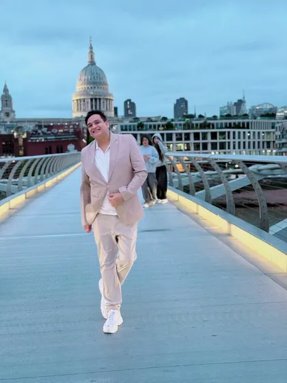 Walking across the Millennium Bridge at dusk. The soft lighting creates a serene and stylish mood.