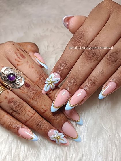 A timeless bridal set with a touch of modern flair. I paired a soft pink base with baby blue French tips, outlined them in gold, and added a delicate 3D floral accent for a truly romantic finish.