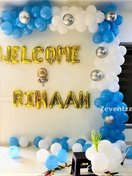 A simple 'Welcome Home' decoration for a baby boy, with a blue and silver balloon garland and foil letters.