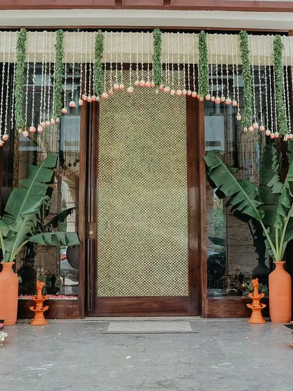 We honor tradition by creating authentic and beautiful settings for sacred ceremonies. This housewarming entrance features traditional thoran made of jasmine and lotus buds, framed by banana plants and terracotta lamps for an auspicious welcome.