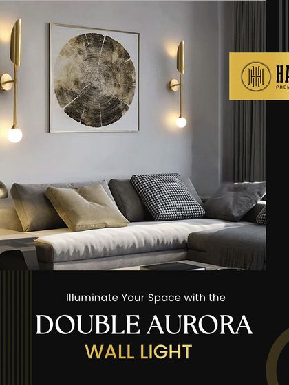 The Double Aurora Wall Light features a sleek, modern design. Its minimalist form and warm glow make it a sophisticated addition to a contemporary living room.