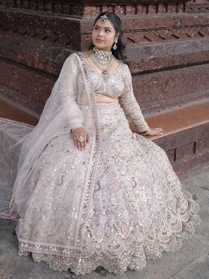 A beautiful outdoor shot of the ivory lehenga, showing how the intricate silver work shines in natural light. A great choice for a day event.