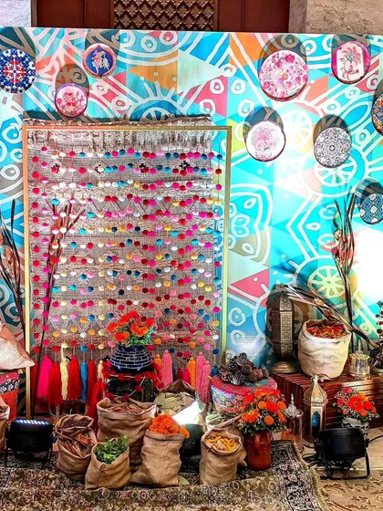 I created this eclectic photo corner inspired by a Turkish spice market. With colorful textiles, burlap sacks, and patterned plates, it provided a unique and interactive backdrop for guests.