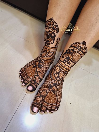 A gorgeous bridal feet design by the team, featuring royal elephants under an umbrella, surrounded by intricate peacock and floral patterns.