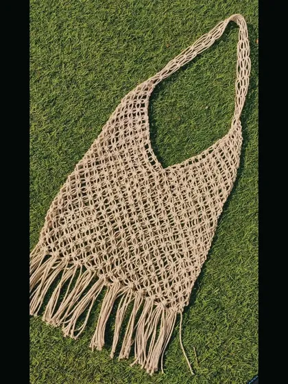 For those who love a more natural, bohemian look, this macrame market bag is perfect. It's made with sturdy cord and features a classic net design with a fringed bottom.