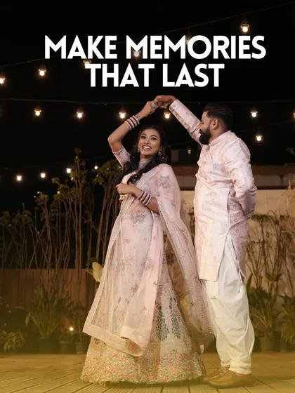 A happy couple shares a dance under the stars and string lights on our rooftop, a perfect memory from their special night.