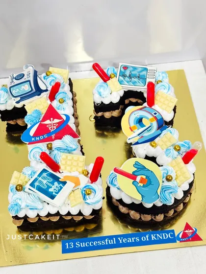 A number '13' cake for the anniversary of a diagnostic center. The design is decorated with medical-themed edible toppers.