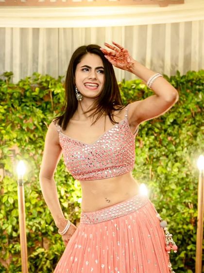 A bridesmaid strikes a pose during her sangeet performance. We make sure every member of the squad gets their moment to shine.