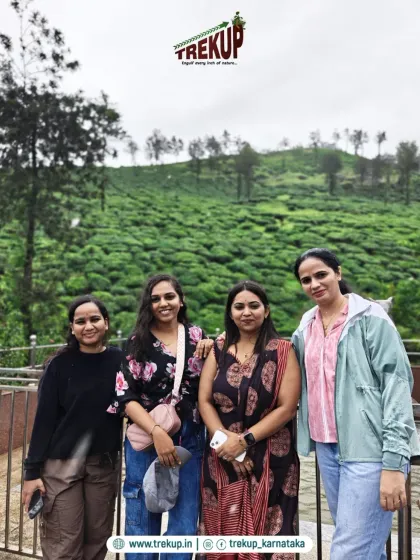 A few friends posing for a photo against the backdrop of a lush tea estate during one of our trips.