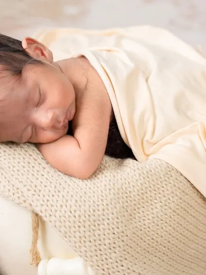 Capturing the tiny details is so important. This close-up shot focuses on the baby's peaceful, sleeping face and tiny hands, highlighting the delicate features you'll want to remember forever.
