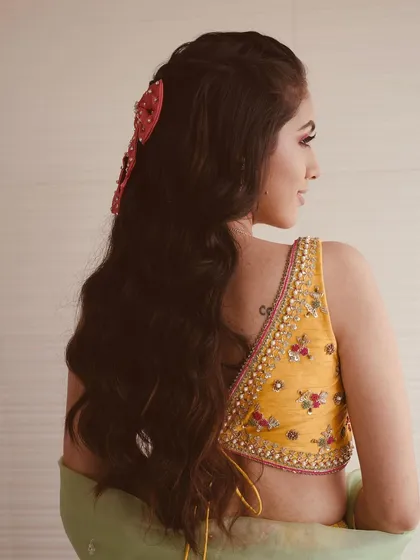 A back view of the half-updo with the red bow, showing how it adds a fun and unique element to the hairstyle.