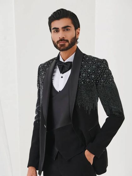 This portrait highlights the intricate pattern of the sequin work and the sharp cut of the tuxedo jacket.