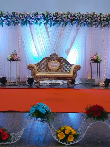 A final wide shot of the reception stage, showcasing the balance of the entire composition, from the floral header to the arrangements at the front.