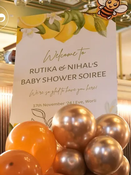 A custom welcome sign for the honey bee themed "Baby Shower Soiree," complete with a cute bee illustration and surrounded by warm, golden hued balloons.